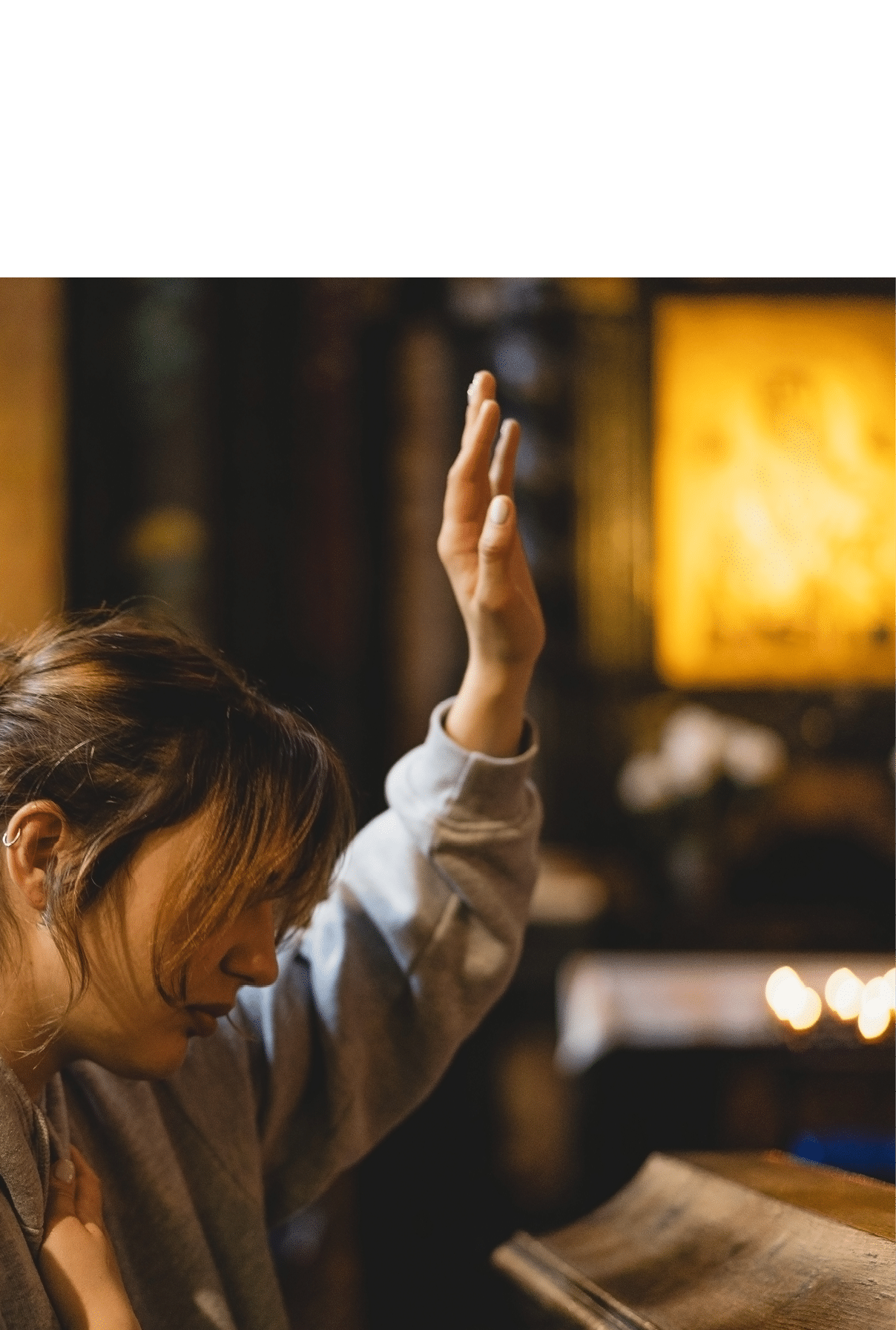 Woman praying on her knees in an ancient Catholic temple to God. Hands folded in prayer concept for faith, spirituality and religion. Peace, hope, dreams concept